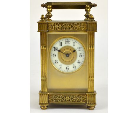 A circa 1900 French brass carriage clock with fluted corners and pierced floral borders, the circular enamel chapter ring set