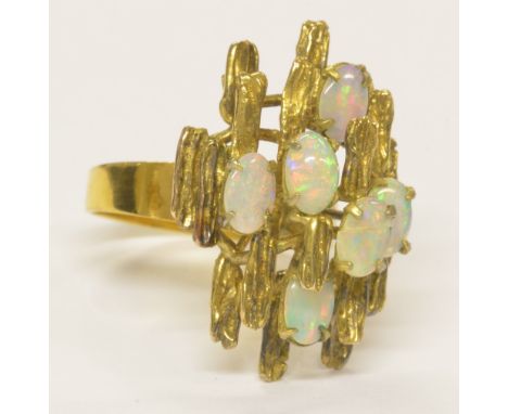 A 14ct yellow gold and opal ring with textured stepped high setting with six oval opals, ring size P1/2, approx 5.5g.