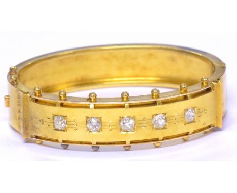 A Victorian yellow metal hinged snap bangle set with five old European round and oval cut diamonds, totalling approx 1.10cts,