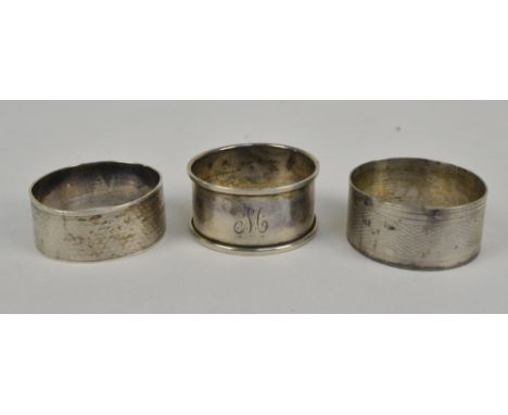 Three hallmarked silver circular napkin rings to include two engine turned decorated examples, one by George Henry Cowell, Lo
