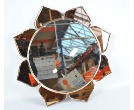 An Art Deco style clear and peach glass floral wall mirror, diameter 58cm.