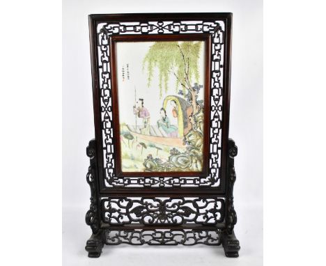 A Chinese Republic period hand painted porcelain plaque depicting figures in a boat, signed, mounted within an elaborate pier