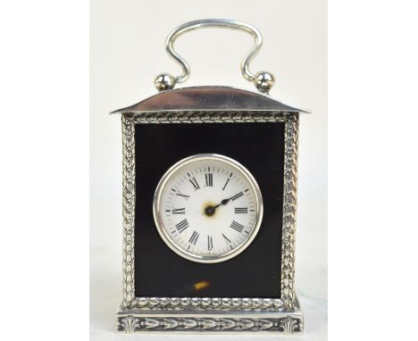 A George V hallmarked silver and tortoiseshell miniature time piece with domed top and husk decoration to corners and borders