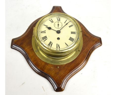 A brass ship's wall clock, the circular enamel dial set with Roman numerals and with subsidiary second dial, diameter 17.5cm,