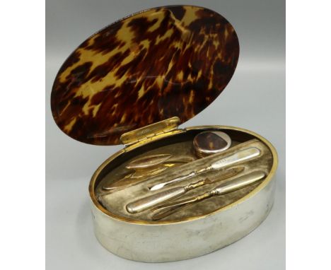 George V hallmarked silver manicure set, oval with hinged tortoiseshell lid, fitted interior with jar and cover, buff and thr