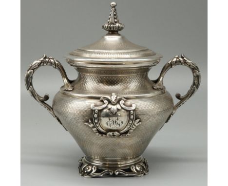 C19th silver plated urn shaped sugar vase and cover, all over engine turned with spire finial, leaf cast handles, and initial