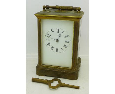 A brass and glass four sided carriage clock