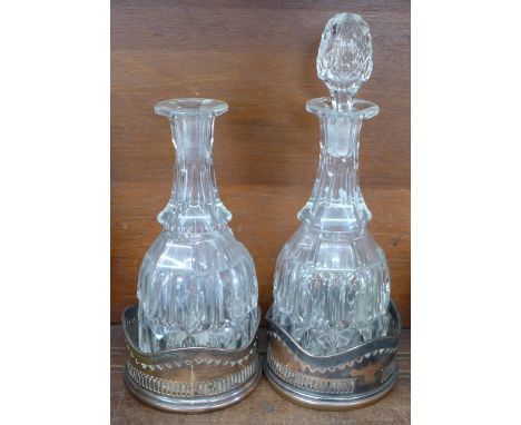 Two decanters with plated coasters, one decanter a/f and lacking one stopper