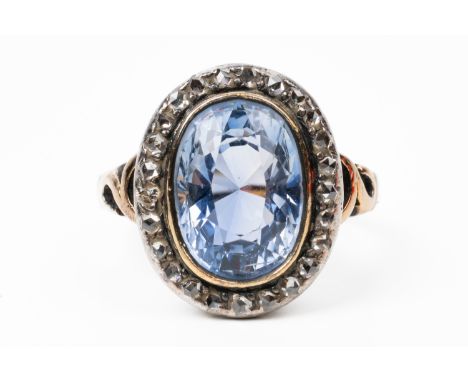 A GOLD AND SILVER SET SAPPHIRE AND ROSE DIAMOND OVAL CLUSTER RINGCollet set with an oval cut sapphire within a surround of ro