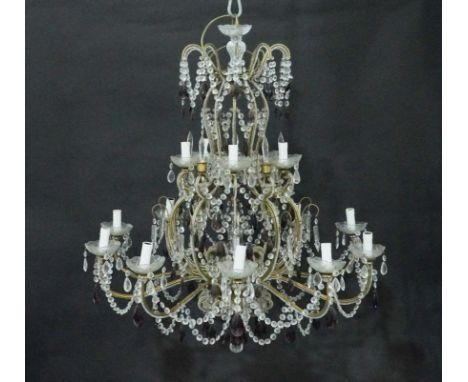 AN ITALIAN GILT-METAL AND GLASS MOUNTED CARTOUCHE SHAPED FIFTEEN LIGHT CHANDELIERWith bead strung scroll arms arranged on two
