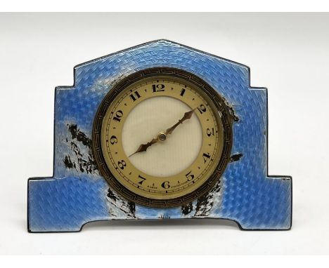 An Art Deco silver and blue enamel eight day Swiss clock hallmarked Birmingham 1931. Damage to the back and enamel as shown. 