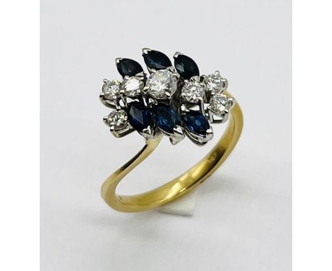 An 18ct gold ring set with 7 diamonds with sapphire surround