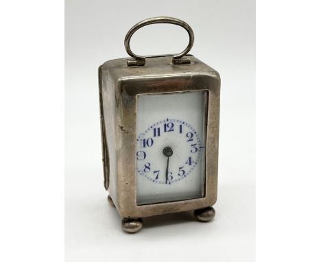 A miniature hallmarked silver clock with white enamelled dial - movement loose in case