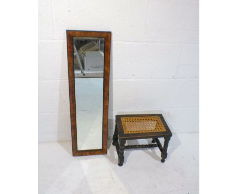 A small bobbin-turned stool along with a rectangular wall mirror.