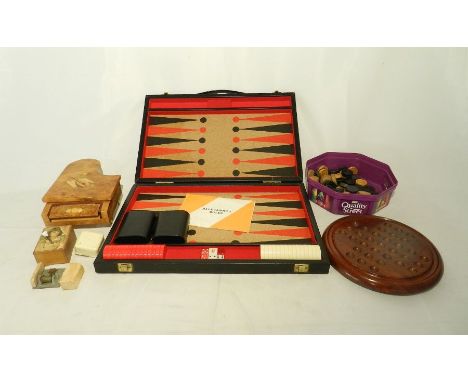 A backgammon set along with a solitaire board, checkers, a music box in the form of a grand piano etc. 