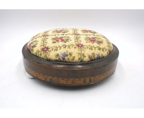 A Victorian inlaid tapestry stool with ceramic feet.