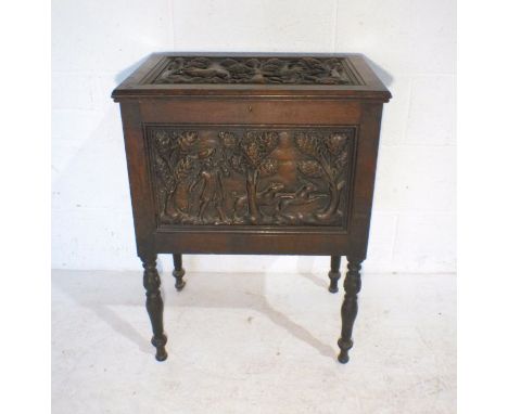 A heavily carved cabinet depicting continental hunting scenes.