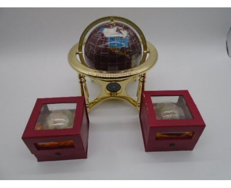 A small gemstone globe with brass supports and compass under (approx. height 25cm), along with two cased gemstone globe paper