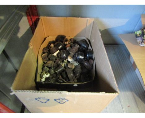 A box of Bakelite light switches and other fittings