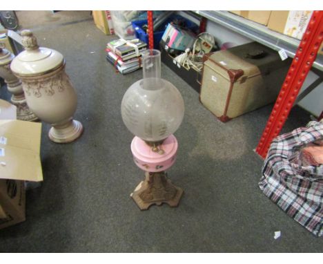 An oil lamp with a pink floral glass reservoir a/f and chimney