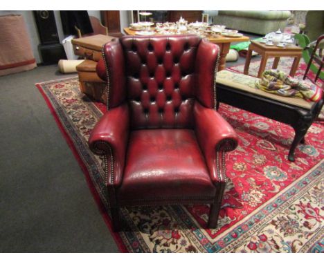 A 19th Century style button-back leather library armchair with brass stud decoration