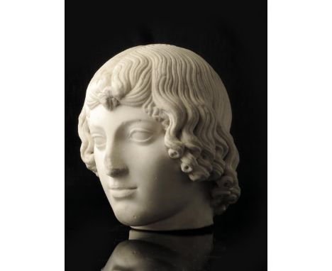 A classical carved marble portrait bust of a boy, with almond eyes and thick curling hair, possibly Roman 2nd / 3rd century A