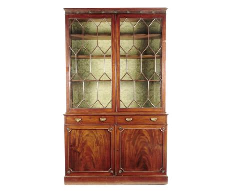 A 19th century mahogany bookcase cabinet, the detachable fluted cornice with carved paterae rondels above a pair of astragal 