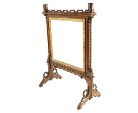 An early Victorian oak Gothic fire-screen, the top with crenellated candle holders above spiral twist columns and with quatre