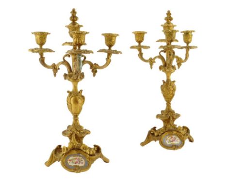 A pair of French ormolu and porcelain mounted four light candelabra in Louis XV style, each with scroll branches and the cent