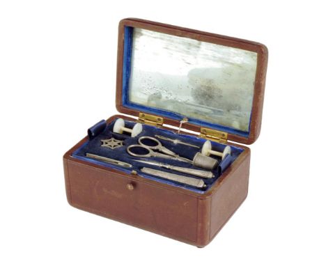 A 19th century French red leather musical étui, with a strap handle above a fitted interior with a mirror to the lid and with