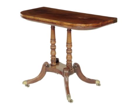A Regency mahogany card table, inlaid with ebonized edging, the 'D' shape hinged and swivel top, on twin ring turned baluster