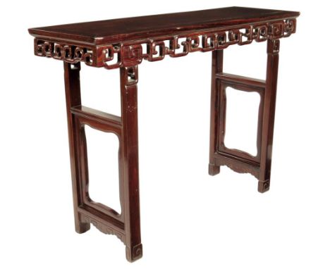 λ A Chinese rosewood altar table, the panelled top above a carved fret frieze, on open panelled legs with scroll feet, late 1