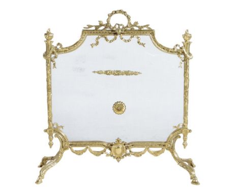 A French gilt brass fire-screen in Louis XV style, decorated with ribbon tied swags and flaming finials on scroll leaf and ho