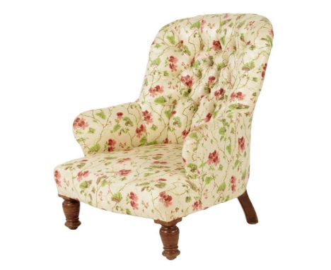 A late Victorian walnut lady's armchair, the button upholstered back on turned front legs.