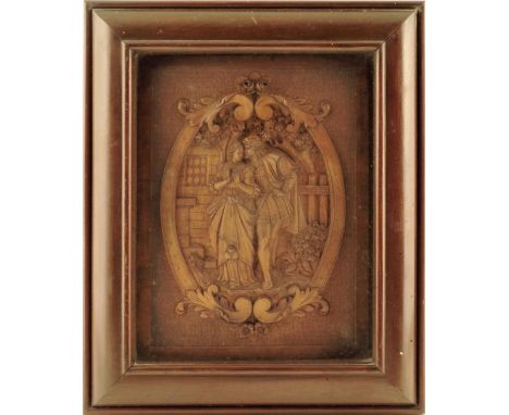 A late 19th century continental carved walnut plaque, depicting an amorous couple in front of trees and a building in a scrol