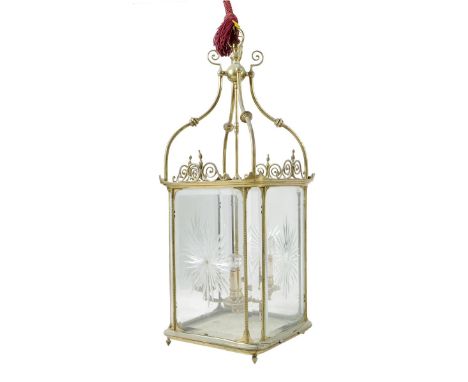 A late 19th century gilt brass hall lantern, with four cut and bevelled glass panels with beaded edges and with scroll decora