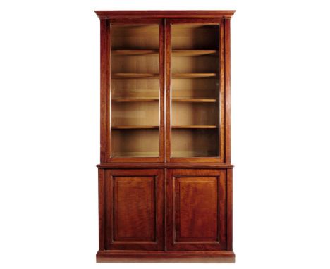 A Victorian mahogany bookcase by Holland & Sons, with a pair of glazed doors enclosing four adjustable shelves, flanked by pi