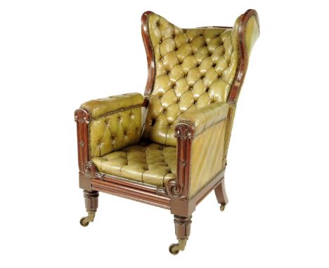 A George IV mahogany library armchair, button upholstered with green leather, the wing reclining back above scroll and lappet