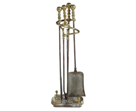 A 19th century brass fire companion set, comprising: three fire tools, each with ball finials on a matching stand with a scro