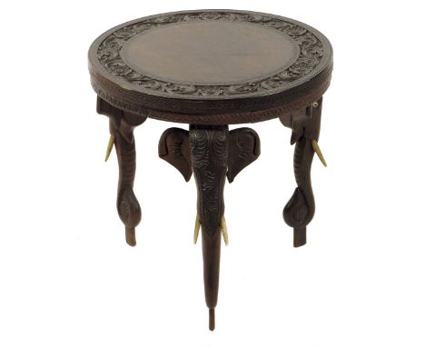 An Indian hardwood occasional table, on three elephant's head and trunk legs, late 19th / early 20th century, 39.1cm high, 37