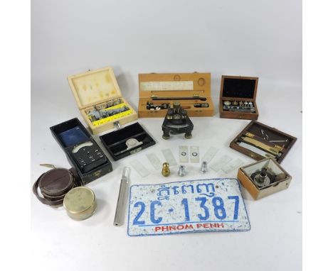 A collection of various scientific instruments and weights, together with a Vietnamese car licence plate