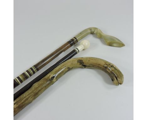 An early 20th century walking stick with an ivory handle, together with two other walking sticks