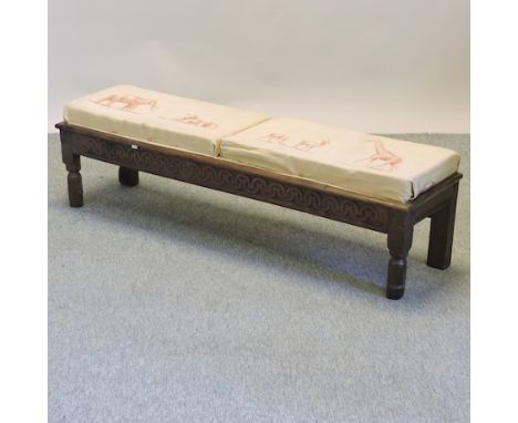 A 19th century carved oak long footstool, with animal print upholstery, 150cm