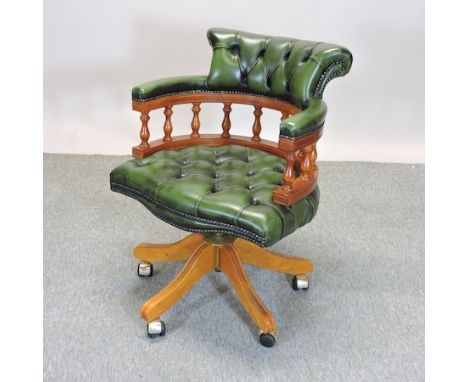 A reproduction yew wood and green leather upholstered button back desk chair