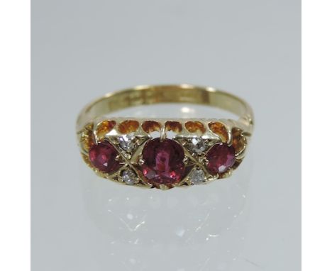 An 18 carat gold ruby and diamond three stone ring, boxed