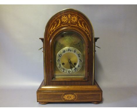 AN EDWARDIAN MAHOGANY INLAID MANTLE CLOCK WITH JUNGHANS MOVEMENT, the arched case with satinwood inlaid decoration, the gilt 
