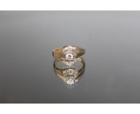 A 585 WHITE GOLD DIAMOND RING, the central brilliant cut diamond being an estimated 0.25 carat, with a further eight diamonds