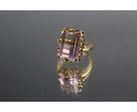 AN UNUSUAL 9K FLOURITE TYPE RING, the central stone being half ink, half yellow in colour and measuring 1.5 cm x 1 cm, ring s