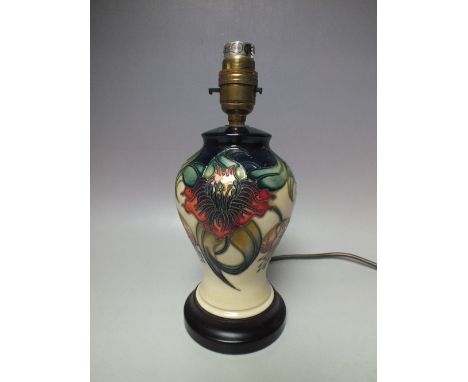 A MOORCROFT 'ANNA LILY' PATTERN SMALL TABLE LAMP, raised on a circular wooden base, tubeline decoration, overall H 25.5 cm to