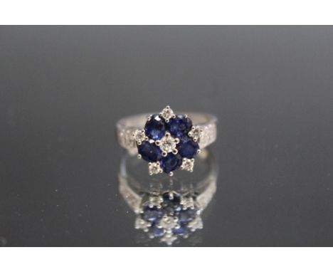 AN SAPPHIRE AND DIAMOND CLUSTER RING, set with five round sapphires totalling estimated 1.25 carat together with six brillian